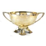 A George V hallmarked silver Arts & Crafts large twin-handled footed bowl, hammered finish,