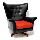 A G-Plan retro wing armchair upholstered in button back black leatherette,