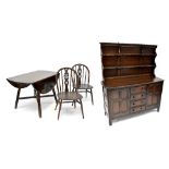 An Ercol dark stained dining suite comprising a dropleaf table,