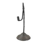An 18th century combination wrought iron rush light and candle holder on stepped metal base,