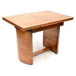 An Art Deco walnut draw-leaf table of rectangular form on half cylinder supports united by