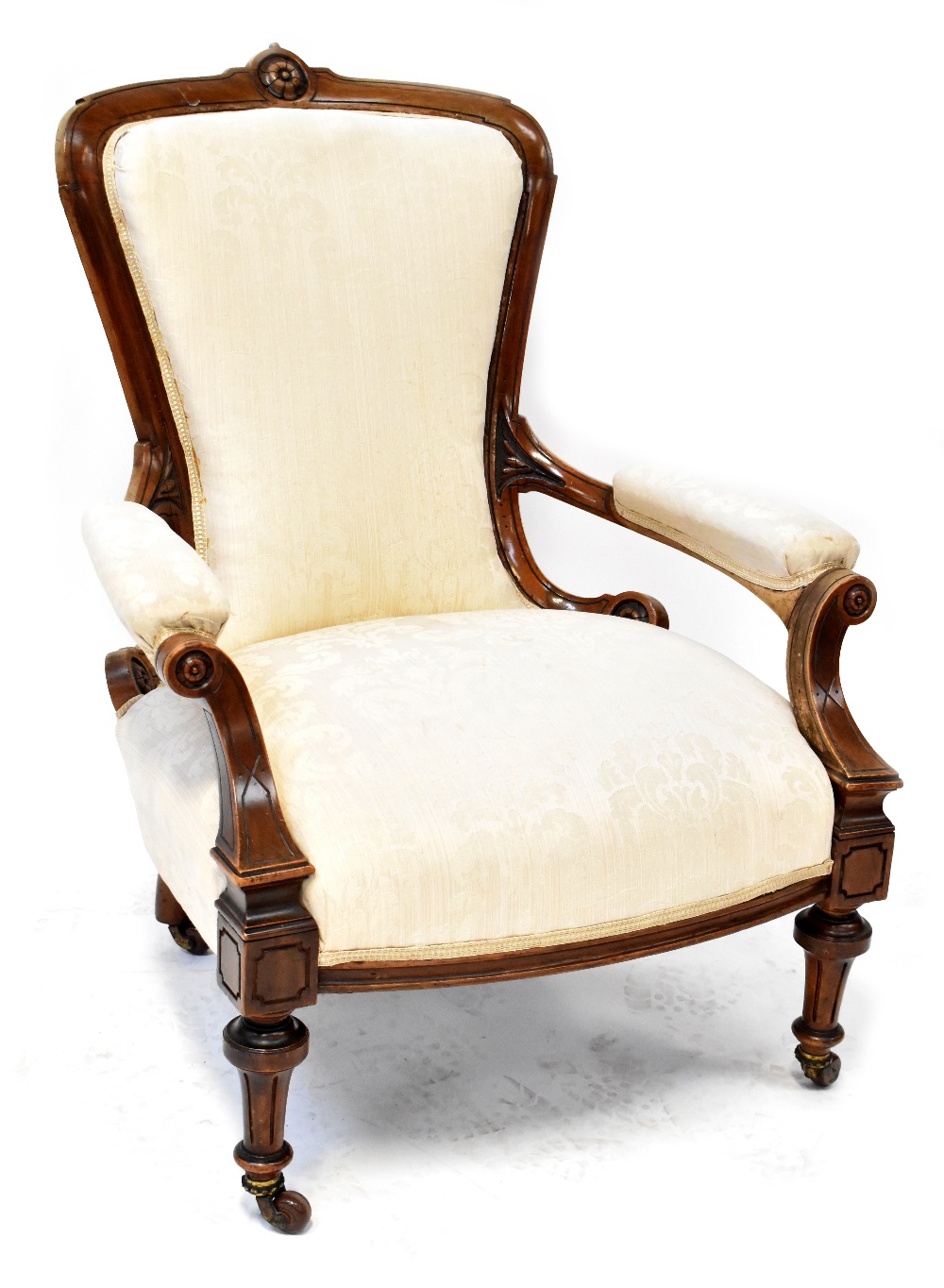 A Victorian walnut spoon back open armchair with scroll ends, upholstered in cream damask,