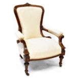 A Victorian walnut spoon back open armchair with scroll ends, upholstered in cream damask,