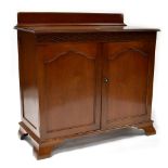 A reproduction mahogany side cabinet with raised plinth above blind fret carved frieze and pair of