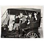 The Beatles; a black and white photograph depicting the Fab Four in a vintage motor car,
