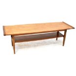 A retro c1960s teak coffee table with lower magazine shelf to tapering rounded supports,