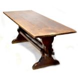 An oak plank top refectory table of rectangular form on stile ends united by stretchers,