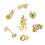 Seven hallmarked gold charms to include a 15ct tiger, the rest are 9ct and include a Vespa, dancers,