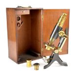 A Wray of London brass and lacquered metal cased microscope with drawer containing eight slides and