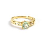 An 18ct yellow gold ladies' dress ring with oval aqua tourmaline and three small diamonds to either