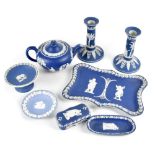 A collection of dark blue Wedgwood jasperware comprising teapot, pair of candlesticks, a tray,