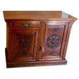 An Edwardian walnut sideboard with single drawer and two carved panel doors, on plinth base,