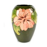 A Walter Moorcroft green ground 'Hibiscus' pattern vase of ovoid form,