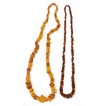 A butterscotch coloured raw amber graduated necklace, length 86cm, approx 111.5g, and a dark raw