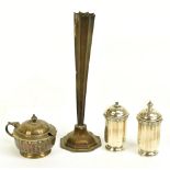 A George V hallmarked silver three piece cruet, with a cast top rim stylised detail above panelled