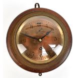 A brass cased and oak mounted eight day ship's clock, the circular dial set with Arabic numerals and