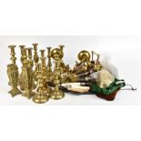 A group of brass candlesticks and further metalware including two teapots, twin branch wall light