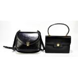 GUCCI; a black leather D-shape cross body shoulder bag with front flap, the silver and gold tone