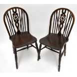 A set of six reproduction oak wheel back dining chairs raised on turned supports (6).