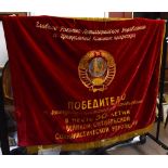 A Russian banner depicting Vladimir Ilyich Lenin to one side with hammer and sickle to the