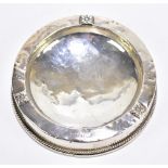 ALBERT EDWARD JONES; a George V hallmarked silver mounted ashtray with relief foliate detail to rim,