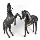 A pair of mid 20th century large leather clad models of horses, one rearing on hind legs the