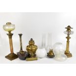 Four oil lamp bases, the tallest with clear cut glass reservoir above Corinthian-style capital to