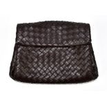 BOTEGA VENETA; a brown intrecciato calf leather clutch bag with cotton lining and a magnetic