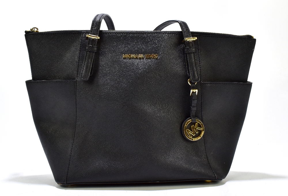 MICHAEL KORS; a black jet set leather tote bag with gold tone hardware base studs, zip, buckles