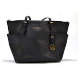 MICHAEL KORS; a black jet set leather tote bag with gold tone hardware base studs, zip, buckles