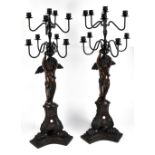 A pair of bronzed metal candelabra with rotating sconces and columns modelled as winged cherubs on