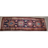 A Persian Ardabil runner with geometric decoration on navy, red and cream grounds, Out of the