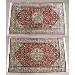 A pair of hand knotted Indian Kashmir silk red ground rugs, both 156 x 96cm with label to reverse (