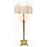 A brass telescopic Corinthian column standard lamp on stepped square section base to paw feet,