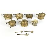 Seven hallmarked silver lidded mustards, including an oval example with repoussé floral