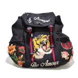 GUCCI; a black nylon backpack with black leather embellishment, decorated with a tiger,