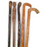 Five walking sticks including an African example with carved figural handle, length 84cm.