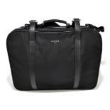 PRADA; a black Saffiano leather and nylon suitcase with detachable strap, removeable leather name
