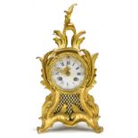 A late 19th century French ormolu Rococo-style eight day mantel clock, the porcelain dial set with