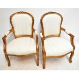 A pair of French style gilt wood open arm elbow chairs on cabriole supports (2).