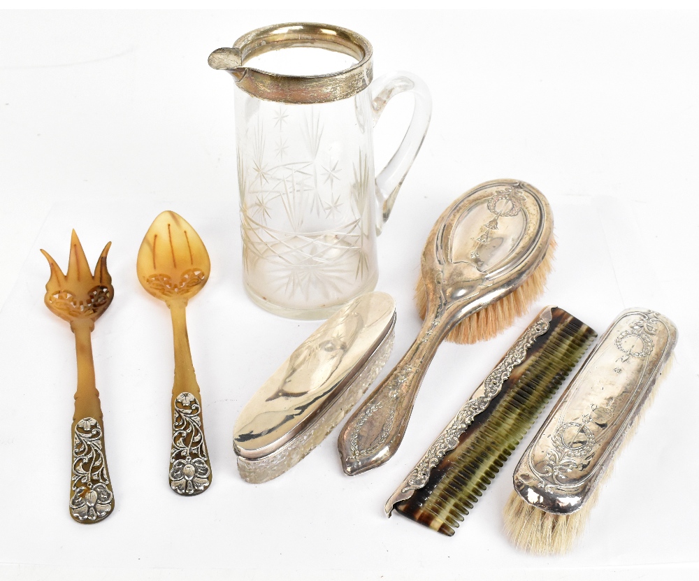 A group of hallmarked silver mounted items to include a cut glass water jug with hallmarked silver