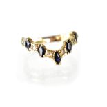 A 9ct gold ring set with five sapphires interspersed with six diamonds in a chevron-shaped mount,