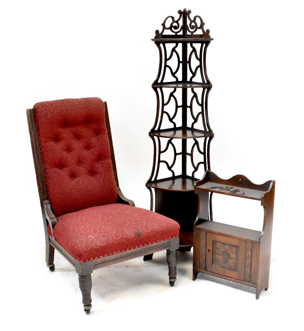 An Edwardian oak-framed nursing chair with button back red upholstery,