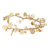A 9ct gold charm bracelet with approximately twenty-six charms to include a pair of slippers,