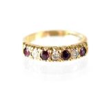 A 9ct gold ring set with four garnets alternated with three diamonds in claw settings, stamped 375,