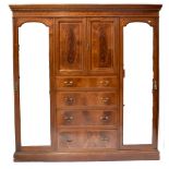 An Edwardian inlaid mahogany triple compactum wardrobe with pair of cupboard doors enclosing a