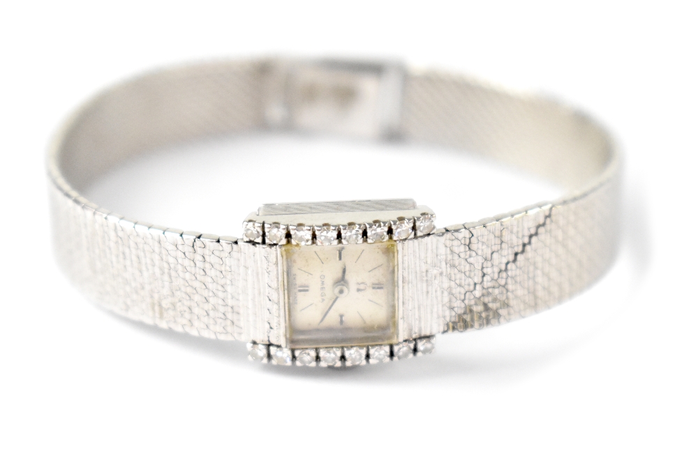 An 18ct white gold and diamond encrusted Omega ladies' wristwatch, marked 750 to the strap,