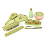 A 1930s Art Deco green Bakelite dressing table set comprising hand mirror, two brushes and a comb,