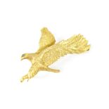 A 9ct yellow gold brooch in the form of an eagle in flight, with a small green stone for the eye,