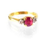 An 18ct gold ring set with central ruby flanked by two diamonds in claw setting, stamped 750,
